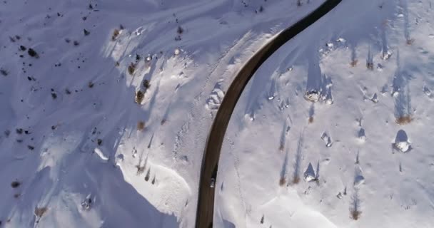 Aérea vertical superior acima da estrada nevada seguindo cars.Sunny pôr do sol ou nascer do sol.Winter Dolomites montanhas dos Alpes italianos ao ar livre natureza estabelecer.4k voo drone que estabelece tiro — Vídeo de Stock