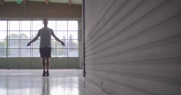 Νεαρός άνδρας ενηλίκων κάνει παρακάμπτοντας άσκηση με το σχοινάκι κατά τη διάρκεια της προπόνηση fitness sport. Grunge βιομηχανική αστική training.4k βίντεο αργής κίνησης — Αρχείο Βίντεο