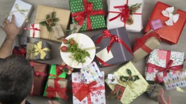 Metin veya logo kopya boşluk bırakarak bazı hediyeler alarak genel gider elleriyle. Ahşap masa Noel hediye kutuları tam dikey üstten görünüm. Xmas tatil sezonu sosyal kartı background.4k video