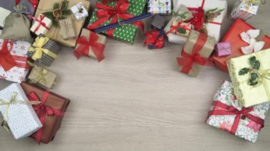 Hediye koyarak genel gider kişi eller üzerinde metin veya logo kopya alanı mevcut. Ahşap masa Noel hediye kutuları tam dikey üstten görünüm. Xmas tatil sezonu sosyal kartı background.4k video