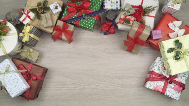 オーバーヘッド人手のテキストまたはロゴにギフトの現在とグリーティング カードを置く領域にコピーします。クリスマス ギフト用の箱の完全な木製テーブルの垂直方向の平面図です。クリスマス ホリデー シーズン社会カード background.4k — ストック動画