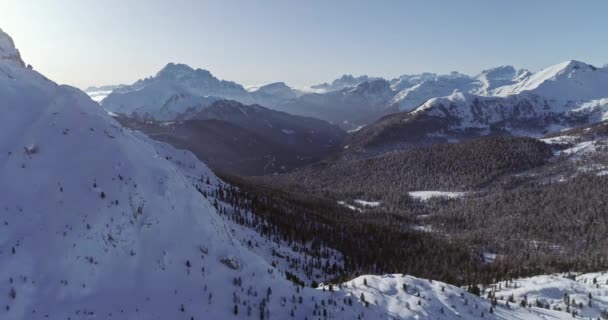 Aérea hacia atrás al valle alpino nevado con bosque de bosques en el paso de Valparola. Soleado atardecer o amanecer, cielo despejado. Invierno Dolomitas Alpes italianos montañas naturaleza al aire libre Establecimiento. — Vídeos de Stock