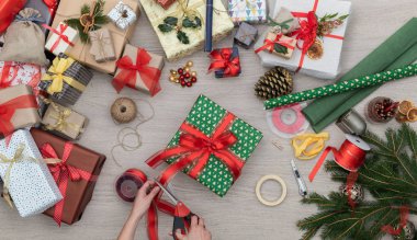 Eller hediye hediye kutusu şerit dikey üst görünümünde ahşap kesme tablo Noel hediye dolu sunar, çam ve el sanatları araçları. Arka plan christmas kış tatil sezon parti insanların sosyal medya kartı