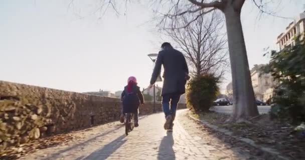 娘子女の子が市の教育パパと一緒に乗って自転車を学習します。成長している、子供の頃、アクティブ セーフティの家族。都市歩道屋外。暖かい夕日寒さ backlight.4k スローモーション 60 p ビデオ — ストック動画