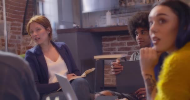 Collega's en klanten praten strategie met laptop en tablet. Groep van multi-etnische mensen die informele zakelijke teamvergadering in restaurant lounge. Teamwork, corporate, diversiteit en sociale concepten — Stockvideo