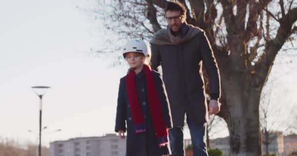 Hija niña aprendizaje segway montar con papá enseñanza en la ciudad.Tecnología de transporte futuro moderno.Familia de seguridad activa.Sidewalk urbano al aire libre.cálida puesta de sol fría backlight.4k cámara lenta 60p video — Vídeos de Stock