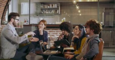 Meslektaşları ve müşterileri dizüstü ve tablet ile strateji konuşmak. Grup gayri resmi iş takım toplantısı Restoran salonda çok ırklı insan. Takım çalışması, kurumsal, çeşitlilik ve sosyal mefhumlar