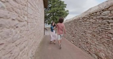 Romantik Çift ziyaret mutlu kırsal kasaba, Assisi.Back yürüyüş izleyin. Arkadaşlar Umbria.4k yavaş çekimde İtalyan yolculuk