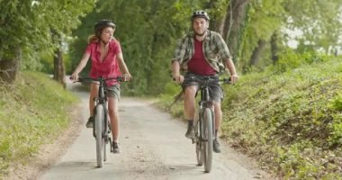 Romantik aktif çift sürme e-bike Bisiklet mtb güzel açık ormanda yol üzerinde. Geniş atış. Arkadaşlar Umbria.4k yavaş çekimde İtalyan yolculuk