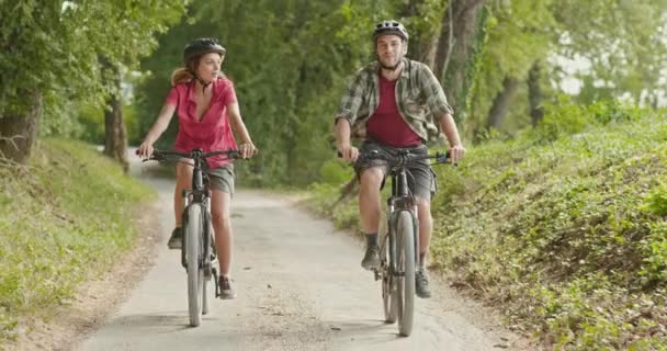 Romantico coppia attiva equitazione e-bike biciclette mtb su un bel sentiero boschi all'aperto.Ampio shot.Friends viaggio italiano in Umbria.4k rallentatore — Video Stock