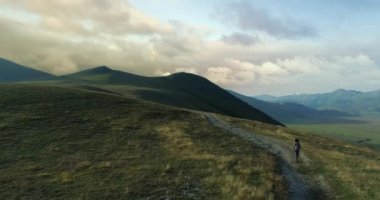 Havadan görünümü hiking uzun yürüyüşe çıkan kimse adam ya da Castelluccio di Norcia yakınındaki bir iz yolu üzerindeki gündoğumu veya günbatımı açık yürüyüş üstünde uçan. İleriye doğru yaklaşıyor. Arkadaşlar Umbria.4k dron İtalyan gezisi