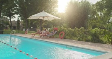 Rahatlatıcı ve yakınındaki lüks kırsal villa evinde Yüzme Havuzu güneşlenme güzel romantik bir çift. Arkadaşlar Umbria.4k yavaş çekimde İtalyan yolculuk