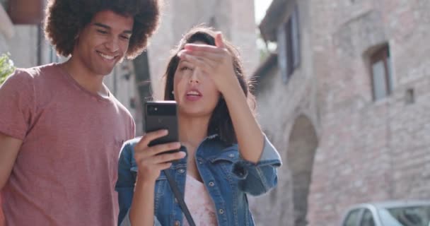 Pareja romántica usando smartphone para buscar servicios o lugares de interés en la ciudad rural de Assisi.Portrait medio shot.Friends viaje italiano en Umbria.4k cámara lenta — Vídeos de Stock