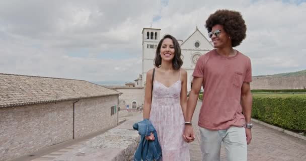Romantic couple walking feeling free and happy to the main square in rural town of Assisi.Medium shot.Friends italian trip in Umbria.4k slow motion — Stock Video