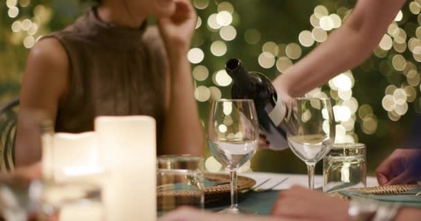 4人、2組のカップルがロマンチックなグルメディナーやランチの間に話したり、食事をしたりしながら、ウェイターが赤ワインを注いでいます。ミディアムショット。ウンブリア.4kスローモーションで友人イタリア旅行 — ストック動画