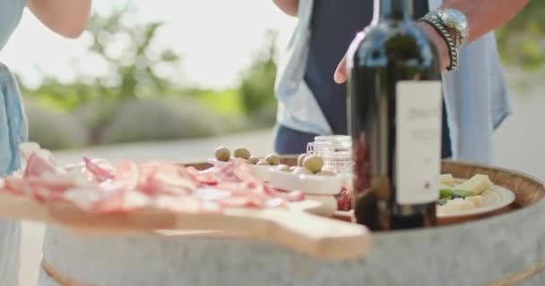 Romantiskt par, man och kvinna rostat med rött vin och äta fingermat förrätt vid varm solnedgång. Mat detalj skott. Vänner italiensk resa i Umbrien. 4K slow motion — Stockvideo