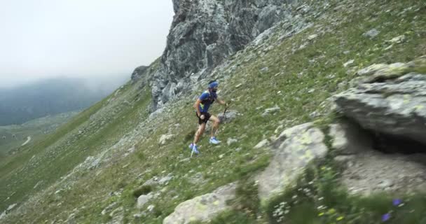 Man Climbing Run auf mountain rise.trail Läufer läuft zum Gipfel Training auf felsigen Anstiegen. Wilde grüne Natur im Freien bei bewölktem Nebel schlechtes Wetter. Aktivität, Sport, Anstrengung, Herausforderung, Willenskraft Konzepte — Stockvideo