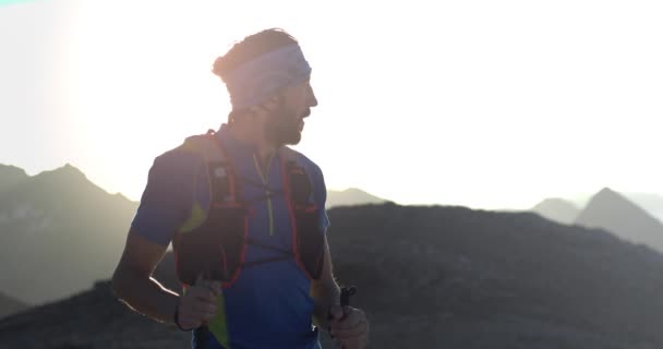 Trail Runner Man Running elérte hegy tetején csúcs cél látszó horizont érdekében. Portré lövés. Vad természet szabadban napkelte vagy naplemente háttérvilágítással. Képzési tevékenység, sport, erőfeszítés, kihívás, akaraterő koncepció — Stock videók