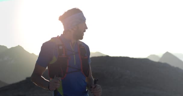 Dağ tepe hedefe ufuk görünümü görünümlü ulaşan çalışan trail koşucu adam. Portre çekimi. Gün doğumu veya gün batımında açık havada vahşi doğa arkadan aydınlatmalı. Eğitim aktivitesi, spor, çaba, meydan okuma, irade kavramı — Stok video