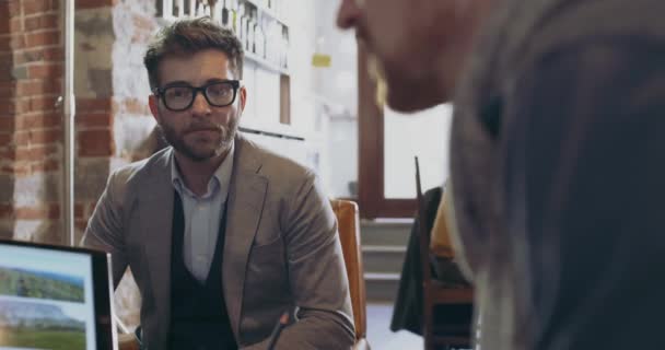 Man showing photos and images on laptop.Group of multiethnic Colleagues and clients people having informal business team meeting in restaurant lounge.Teamwork, corporate, diversity and social concepts — стоковое видео