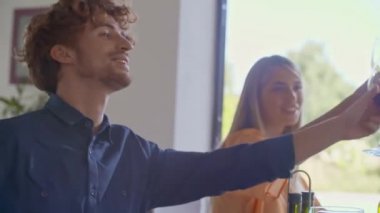 Mutlu arkadaşlar tost, birlikte konuşan şarap içme grubu. İnsanlar grup modern ev partisi akşam yemeği veya öğle yemeği tadını çıkarın. El videosu