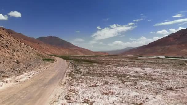 Antenn över grus Off Road Trail nära torra ökenberg i solig dag. Pamir Highway Silk Road Trip äventyr i Kirgizistan och Tadzjikistan öken, Central Asien. 4k Drone flygning skogs video — Stockvideo