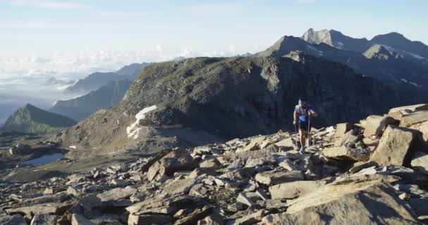 Man klimmen lopen op berg stijgen. Trail runner loopt naar top Peak training op Rocky Climb. Wilde groene natuur buitenshuis bij zonsopgang of zonsondergang. Activiteit, sport, inspanning, uitdaging, wilskracht concepten — Stockvideo