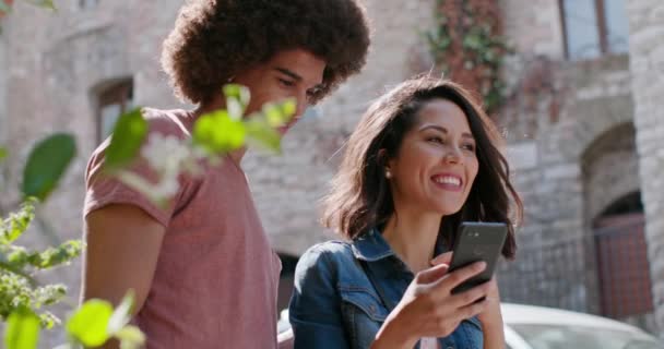 Couple romantique utilisant un smartphone pour rechercher des équipements ou des monuments dans la ville rurale d'Assisi.Portrait tir moyen.Amis voyage italien en Ombrie 4k slow motion — Video