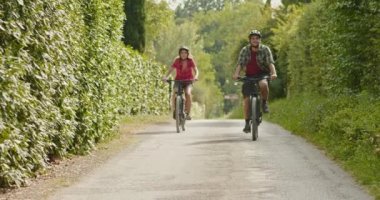 Romantik aktif çift güzel bir açık orman orman yolu yolda e-bisiklet bisiklet mtb sürme. Geniş atış. Umbria.4k yavaş hareket Arkadaşlar İtalyan gezisi