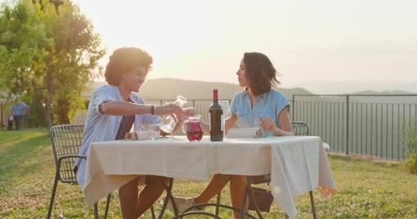 Pareja enamorada feliz hablando, comiendo y bebiendo durante una cena gourmet romántica al aire libre al atardecer. Amigos viaje italiano en Umbria.4k cámara lenta — Vídeos de Stock