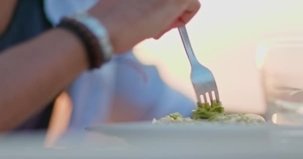 Hombre detalle de la mano comer pasta de espaguetis linguine con tenedor durante la cena gourmet romántica al aire libre al atardecer. Amigos viaje italiano en Umbria.4k cámara lenta — Vídeos de Stock