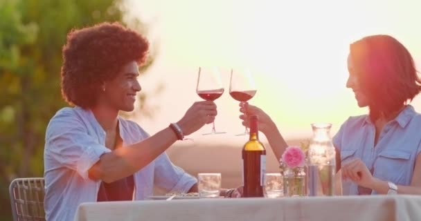 Man en vrouw toasten en drinken van rode wijn tijdens Romantisch Gastronomisch diner buiten bij zonsondergang. Medium schot. Vrienden Italiaanse reis in Umbrië. 4k Slow Motion — Stockvideo