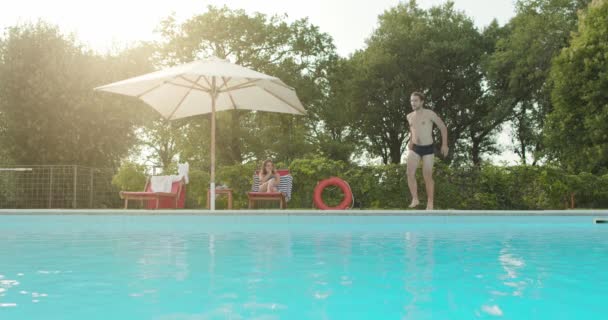 Ο άνθρωπος κατάδυση σε νερό χαλαρώνοντας στην πισίνα την ηλιόλουστη μέρα. Φίλοι ιταλικό ταξίδι στην Ούμπρια. 4K αργή κίνηση — Αρχείο Βίντεο