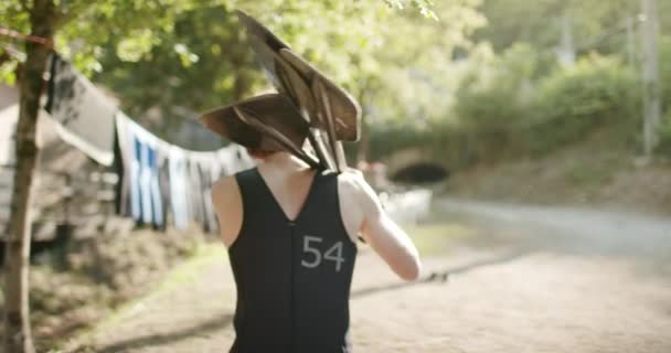 Man lopen met peddels dragen duik pak voor raften of kanoën. Actie sport. Vrienden Italiaanse reis in Umbrië. 4k Slow Motion — Stockvideo