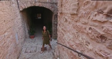 Dört mutlu turist yürüyüş ve Spello.Front kırsal kasaba ziyaret küçük sokak boyunca hayretle çalışan izleyin. Umbria Arkadaşlar İtalyan tatil gezisi.4k yavaş hareket