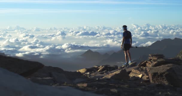 Trail Runner człowiek działa osiągając góry szczyt celu patrząc widok horyzont. Szerokie ujęcie. Dzika przyroda na zewnątrz na wschód lub zachód słońca podświetlony. Ćwiczenie, Sport, wysiłek, wyzwanie, koncepcje siły woli — Wideo stockowe
