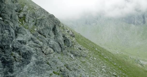 Aerial establisher flight over italian alps mountain riff climbing. Wild green nature outdoor in foggy or cloudy weather. above 4k drone truck — Stock Video