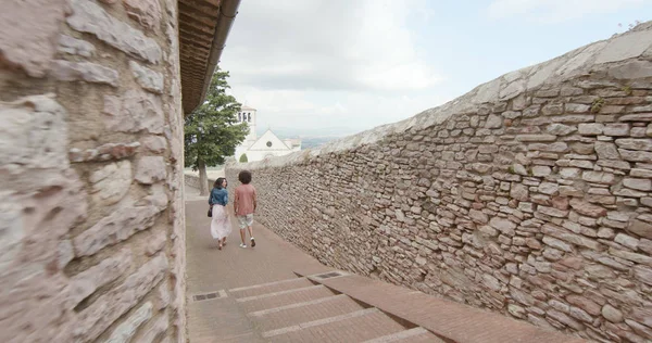 Casal romântico andando visitando cidade rural feliz de Assisi.Back seguir.Amigos viagem italiana em Umbria.4k câmera lenta — Fotografia de Stock
