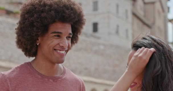 ロマンチックなカップルは、アッシジの田舎町のメイン広場に自由で幸せな気持ちで愛撫を愛撫.ウンブリア.4kスローモーションで友人イタリア旅行 — ストック動画