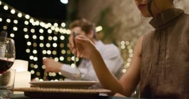 Romantik bir gurme akşam yemeği veya öğle yemeği sırasında çatal kullanarak yerken kadın elleri detay. Geniş atış. Umbria.4k yavaş hareket Arkadaşlar İtalyan gezisi