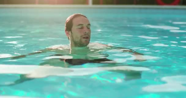 L'uomo in acqua si rilassa in piscina nella giornata di sole.Amici viaggio italiano in Umbria.4k slow motion — Video Stock