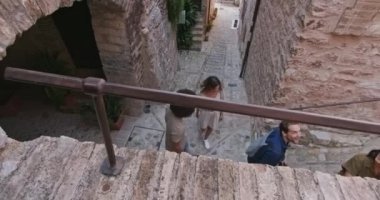 Dört mutlu turist, Spello. kırsal kesimdeki Spello. kasabasında yürürken ve koşarken görülüyor. Umbria .3k 'te dostça bir tatil gezisi.