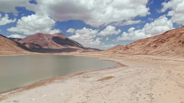 Antenn över Alpin blå sjö och grus torra ökenberg i solig dag. Pamir Highway Silk Road Trip äventyr i Kirgizistan och Tadzjikistan öken, Central Asien. 4k Drone flygning skogs video — Stockvideo