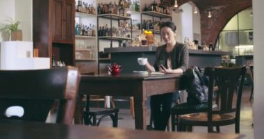 Akıllı telefon cep telefonu kullanarak çay içen kadın. Geniş görünüm rahat giyinmiş asya çinli, iş kadını iş veya kafe, restoran salonu veya kafeterya da okuyan. Modern, birlikte çalışma, çeşitlilik
