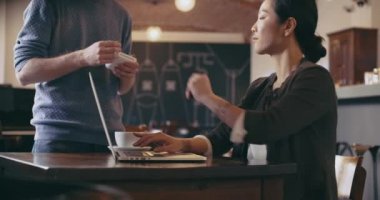 Kredi kartıyla ödeme yapan, dizüstü bilgisayar kullanan kadın. Rahat giyinmiş asya çinli, iş kadını iş çalışan veya kafe, restoran salonu veya kafeterya okuyan. Modern, birlikte çalışma, çeşitlilik