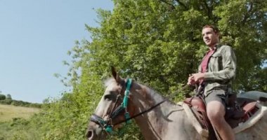 Güneşli bir açık orman tarlasında ata binen dört aktif insan. Umbria.4k yavaş hareket Arkadaşlar İtalyan gezisi