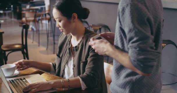 Mujer comprando pagando con tarjeta de crédito, trabajando con laptop.Casual vestido asiático chino, mujer de negocios trabajando negocio o estudiando en la cafetería, restaurante salón o cafeteria.Modern, coworking, diversidad — Vídeo de stock