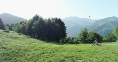Bisikletçi yaz güneşli bir günde orman izi havadan görünümü boyunca dağ bisikleti sürme. Kros bisikletçisi. Anten Mtb bisiklet ipe biniyor. Dağlarda yol boyunca binicilik dağ e-bisiklet