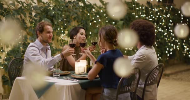 Cuatro personas, dos parejas felices hablando y brindando con vino tinto durante una romántica cena gourmet o almuerzo. retrato medio shot.Friends viaje italiano en Umbria.4k cámara lenta — Vídeos de Stock