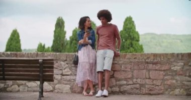 Romantik çift Assisi.Portrait orta çekim kırsal kasabasında akıllı telefon kullanarak. Umbria.4k yavaş hareket Arkadaşlar İtalyan gezisi